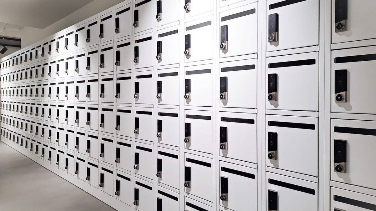 Wall-mounted white electronic lockers with integrated digital locks for secure personal storage in modern facilities.