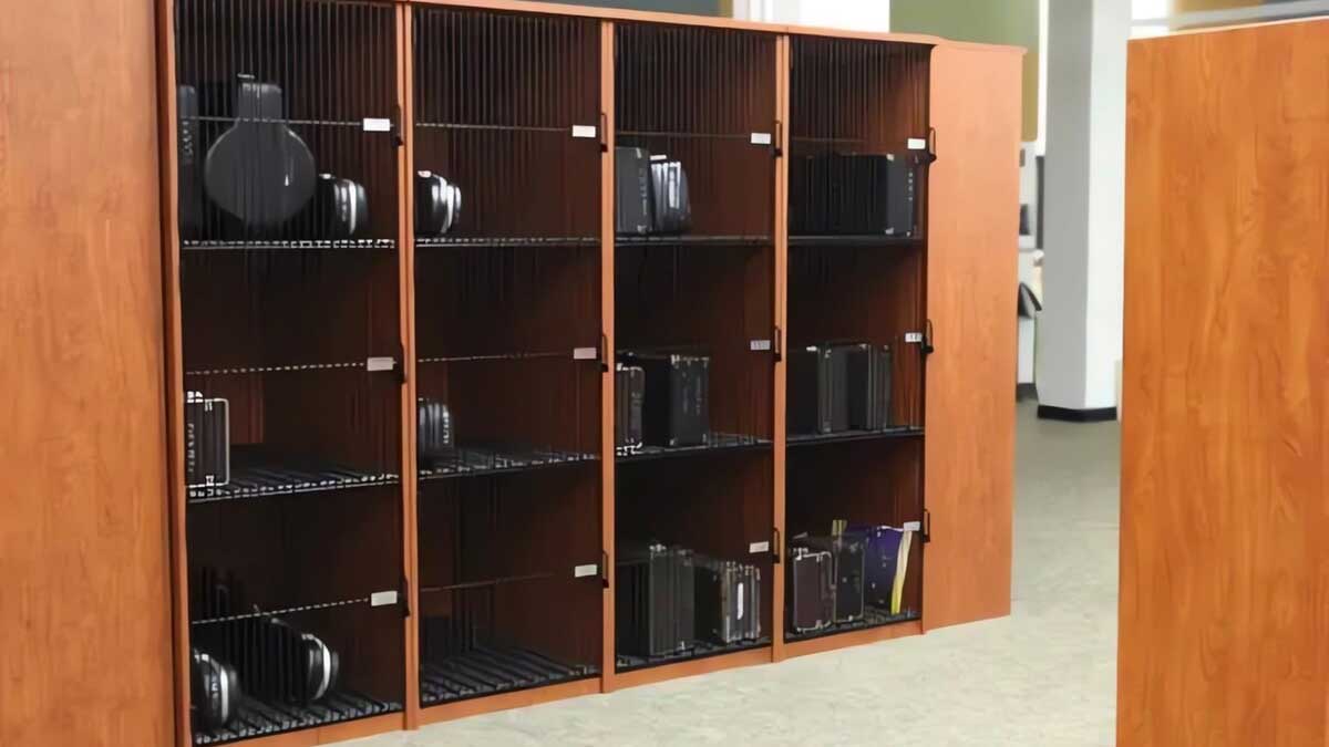 Cherry wood musical instrument lockers with black wire doors storing a variety of band instruments
