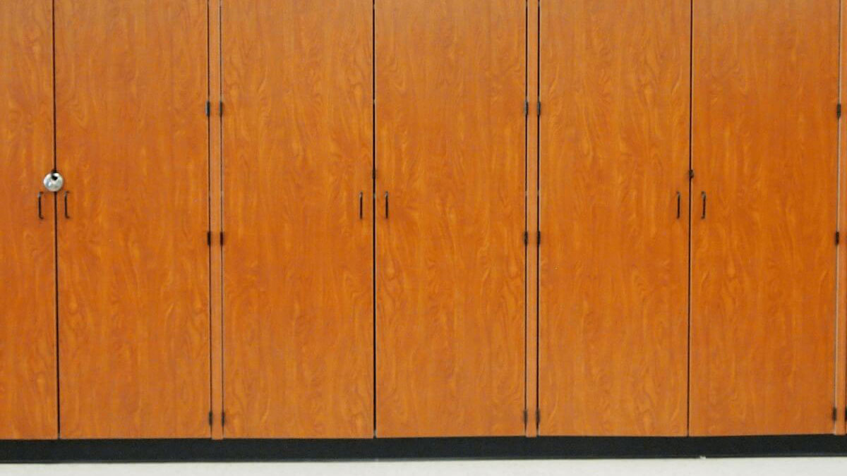 Solid wood band storage cabinets topped with an array of music trophies in a school music room