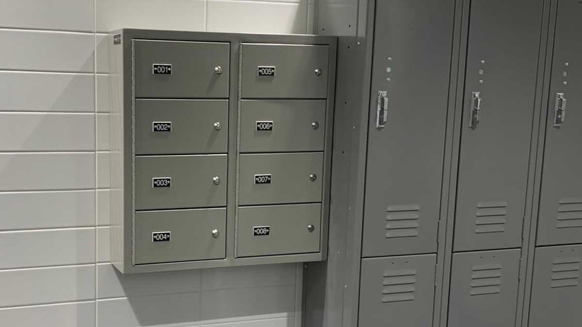 Wall-mounted multi-door handgun locker installed in a law enforcement locker room