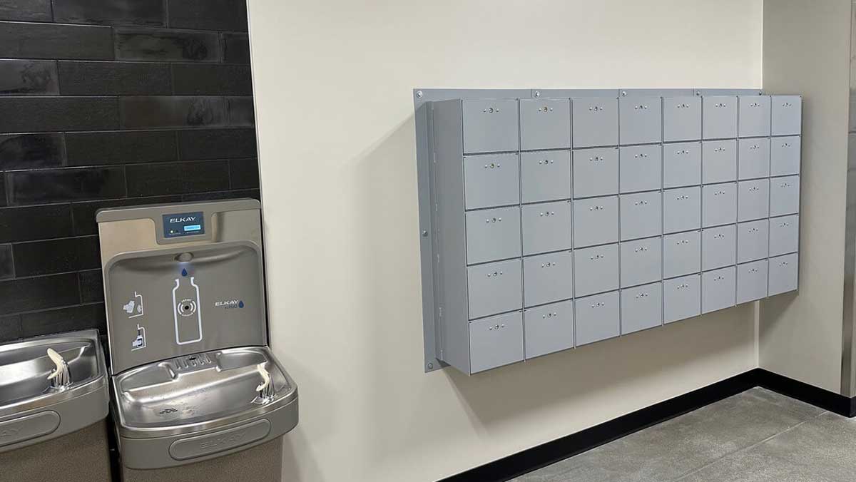 Wall-mounted mini locker bank near water fountains for secure temporary storage in public facilities