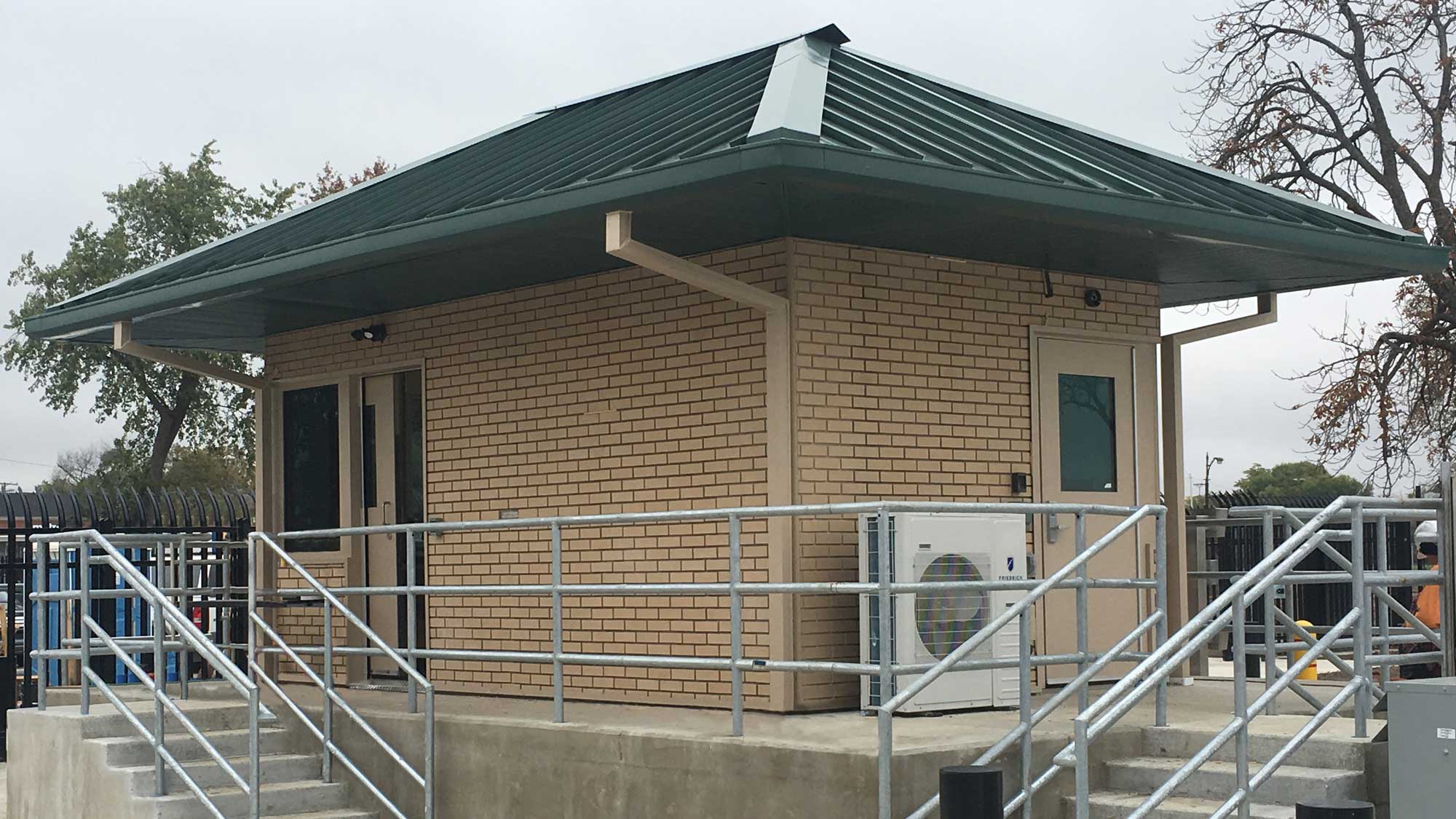 brick security pavilion with ramp and railing for accessible guard entry and site protection