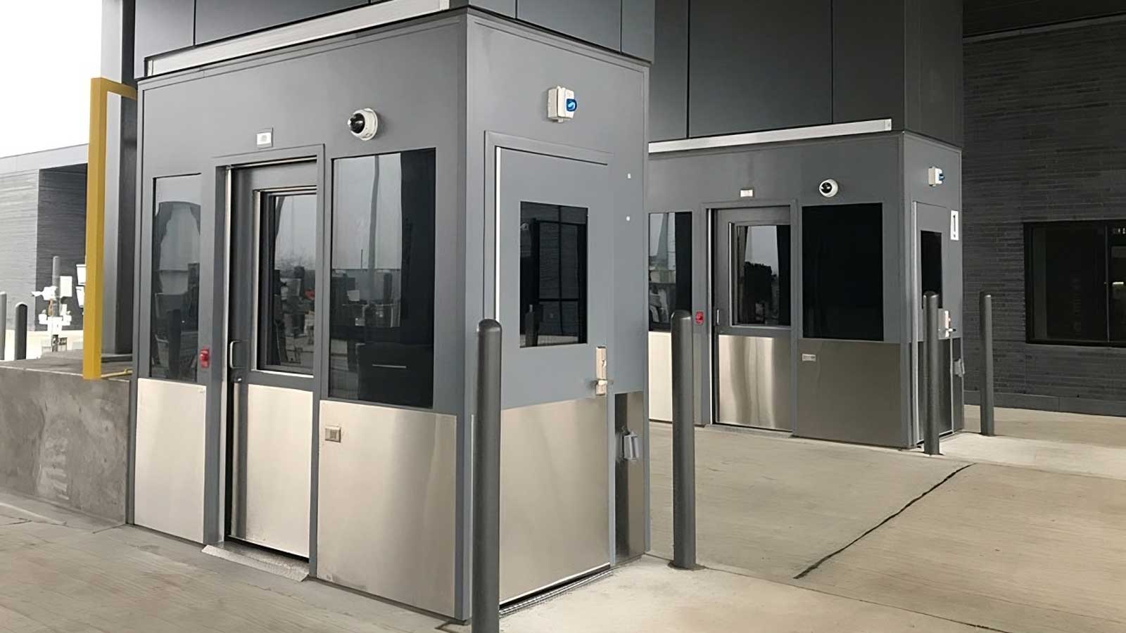 two security kiosks with stainless steel lower panels and dark upper enclosure for dual guard monitoring at entry points