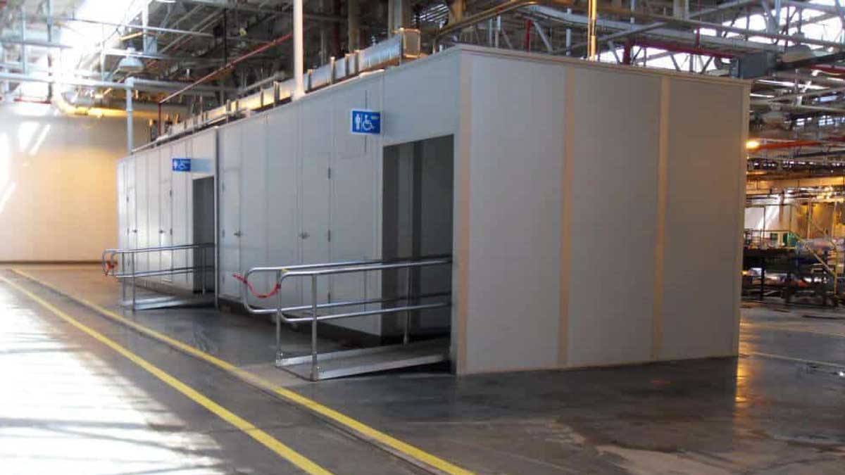 Modular ada compliant restroom for industrial facilities with wheelchair access ramp