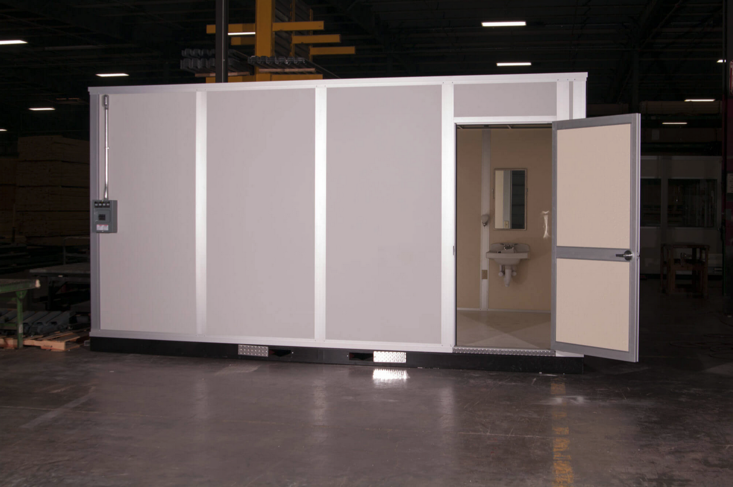 Modular restroom unit featuring a sink and mirror for industrial workspace use
