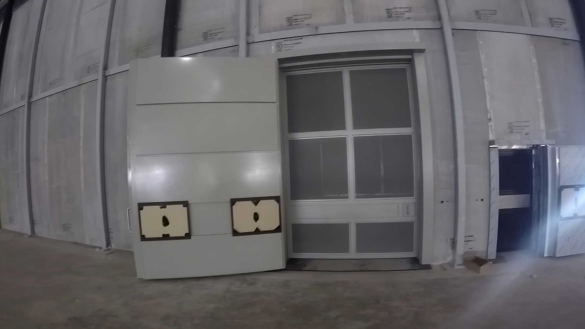 indoor modular vault room with access door and mounted electrical panel for asset security