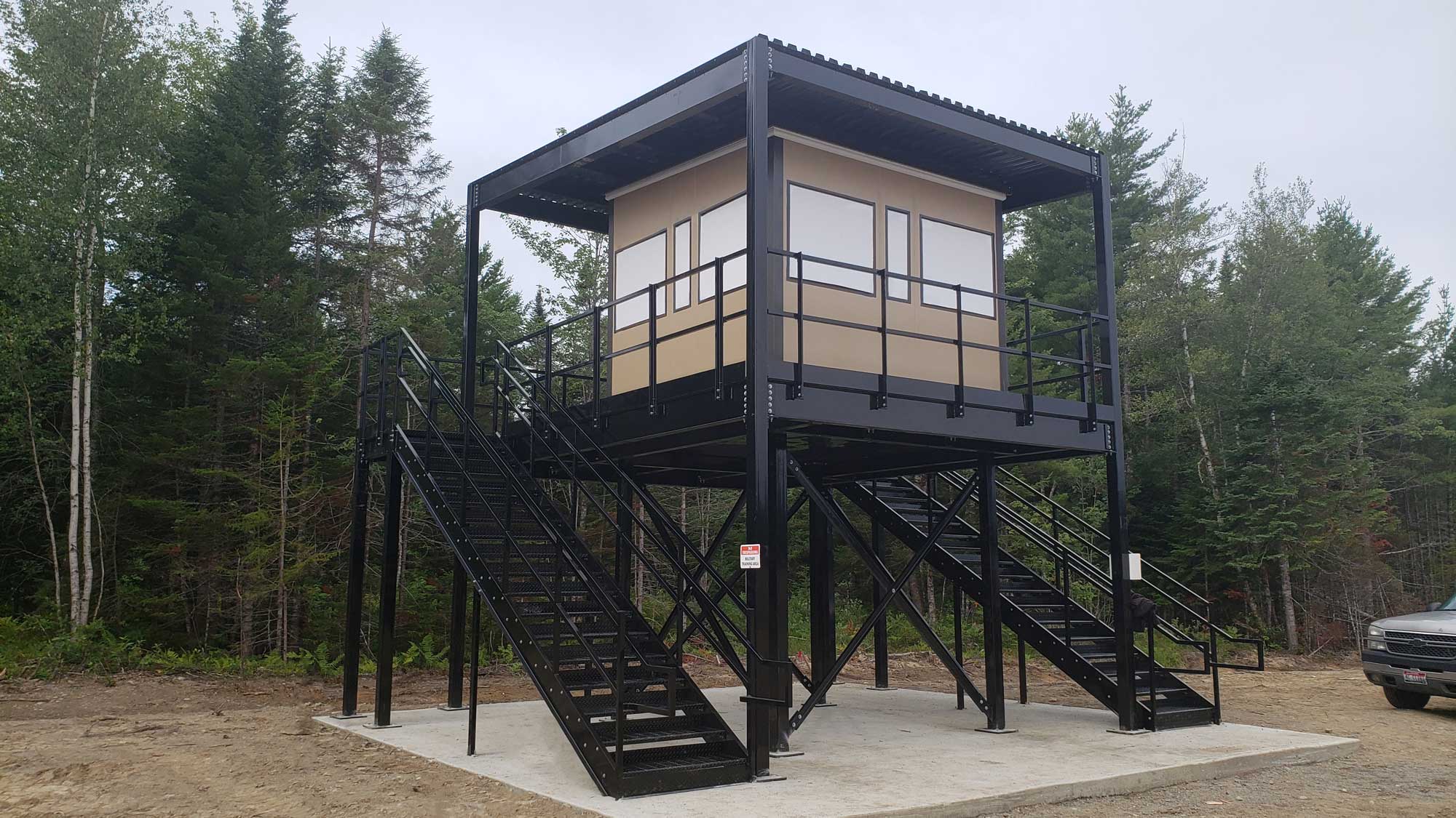 beachside observation tower featuring a railed platform and staircase for coastal surveillance