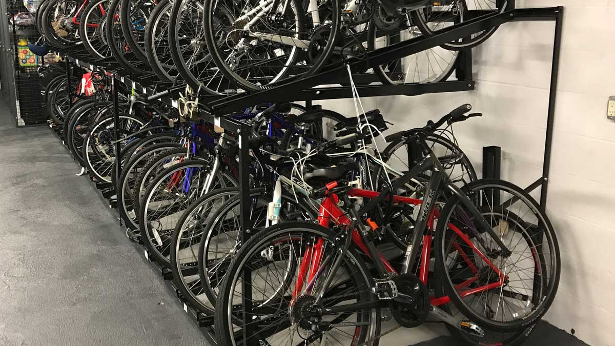 wall-mounted bike hook rail system providing hanging storage for multiple bicycles in indoor facility