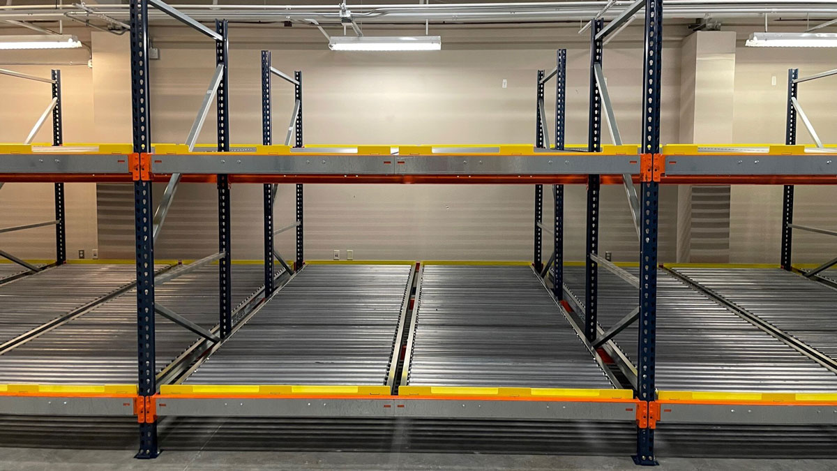 Push back rack storage system with angled shelves for high-density pallet storage and easy retrieval
