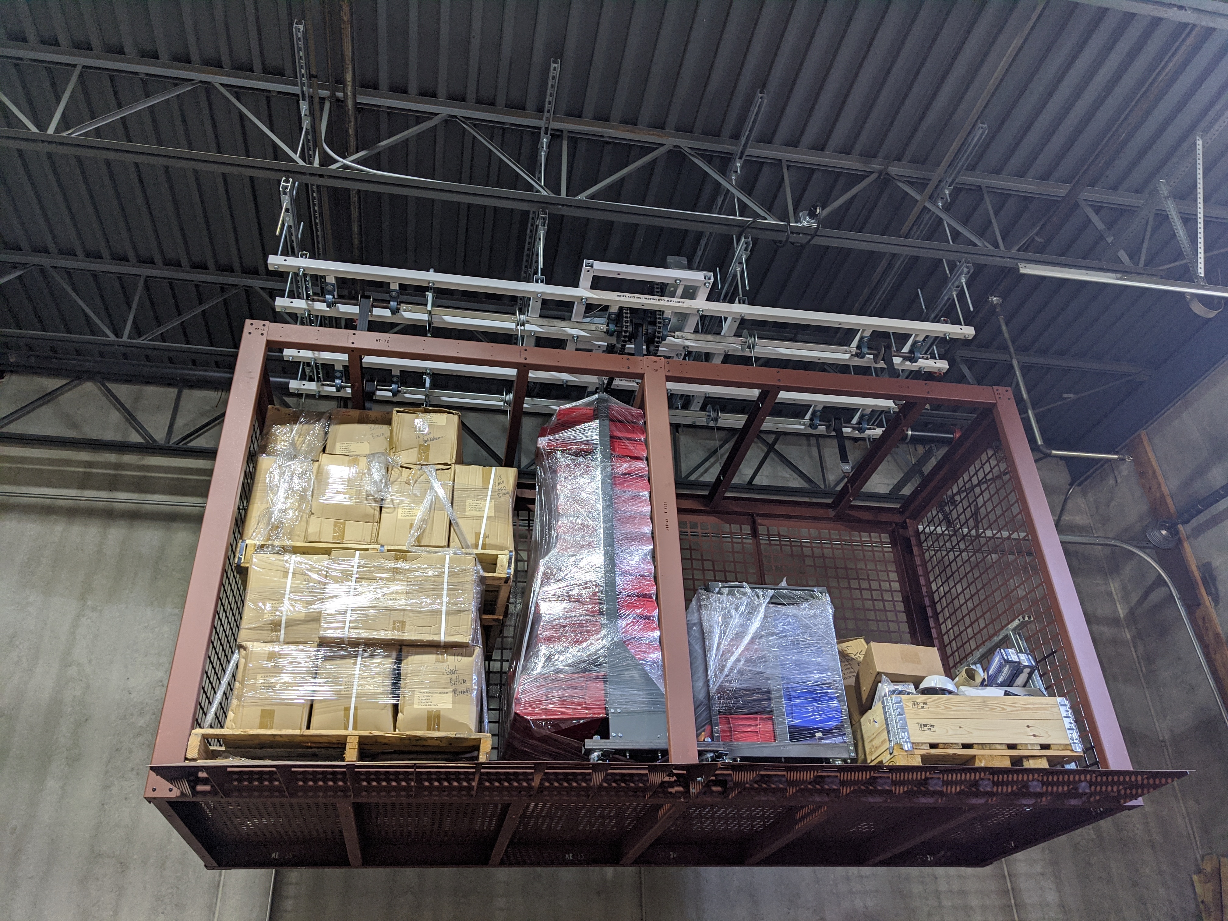 overhead ceiling storage racks installed in a warehouse above forklift aisles
