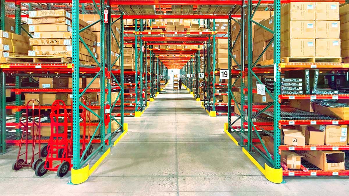 Base guards protecting pallet rack row ends in a distribution center