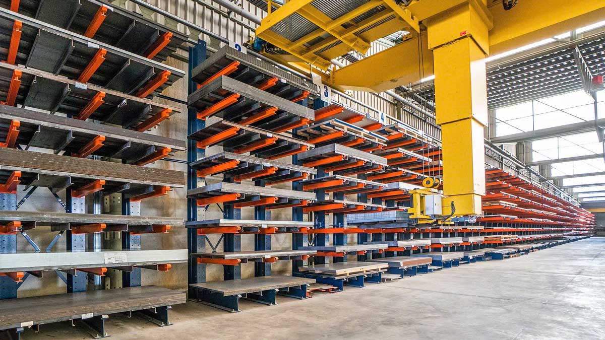 Industrial storage area with automatic overhead cranes and cantilever racking for material handling