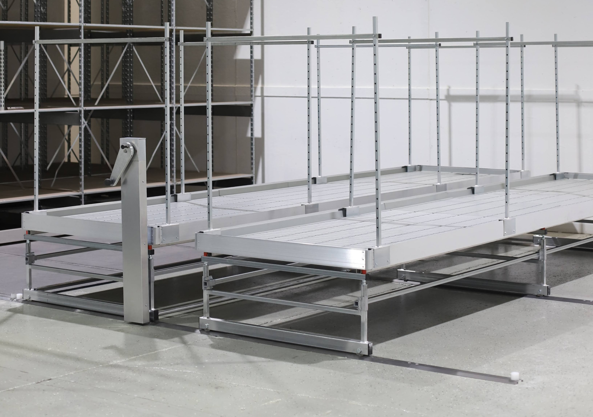 Crank operated rolling bench uses a hand crank to reposition platform benches on floor tracks
