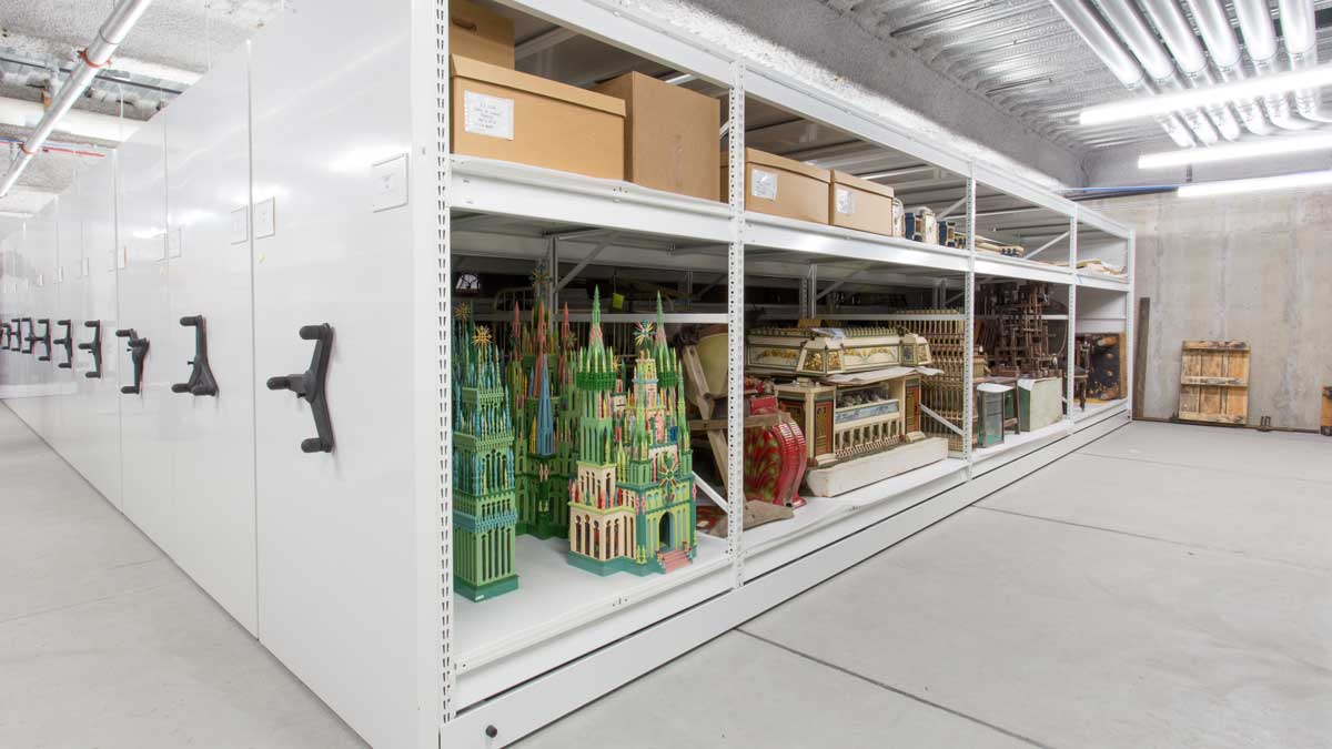 art storage room with mesh panel wall displays and multiple flat file drawers for secure organization