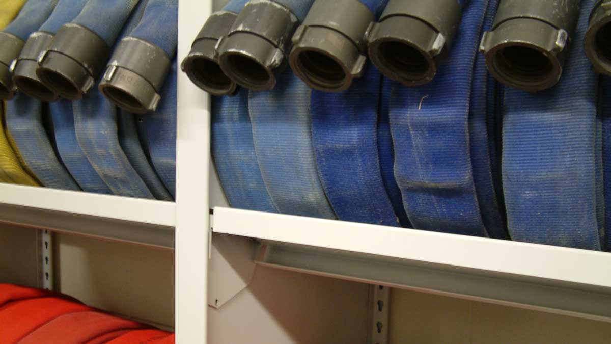 Blue hoses rolled on white steel shelves