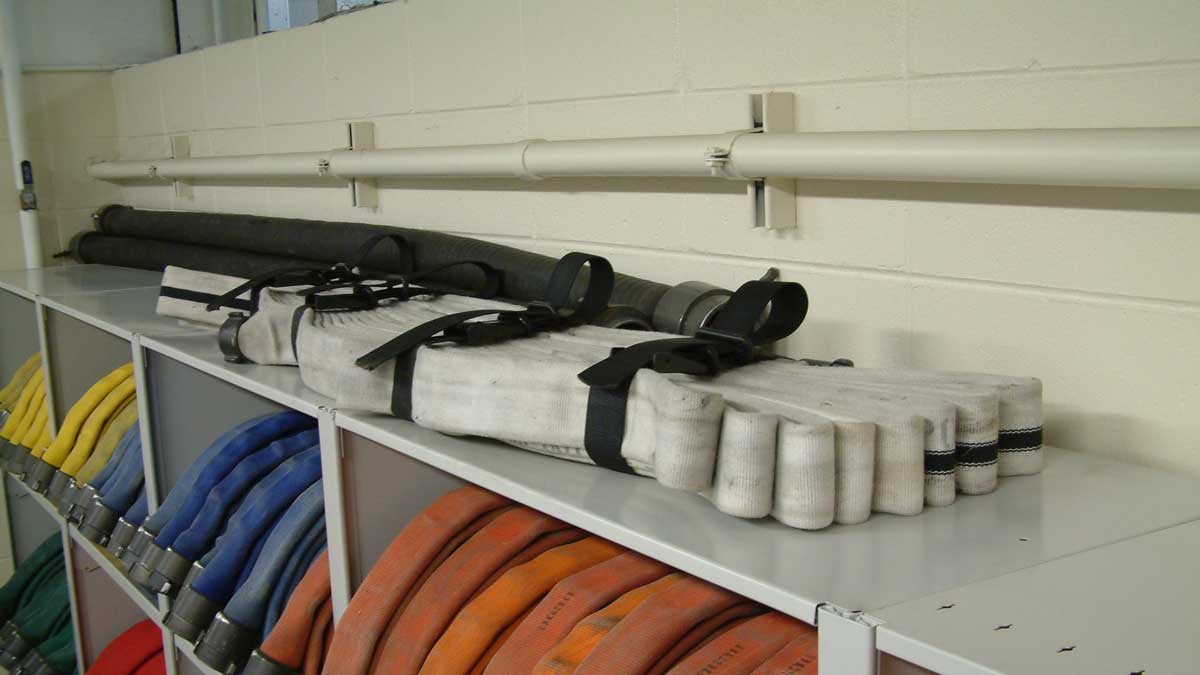 Shelving with folded and coiled fire hoses ready for deployment