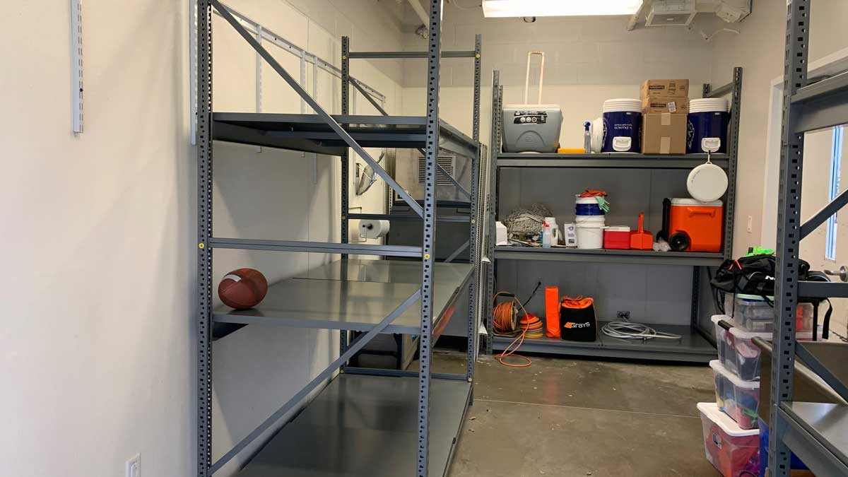 heavy duty grey metal shelving system in storage room with sports and utility gear