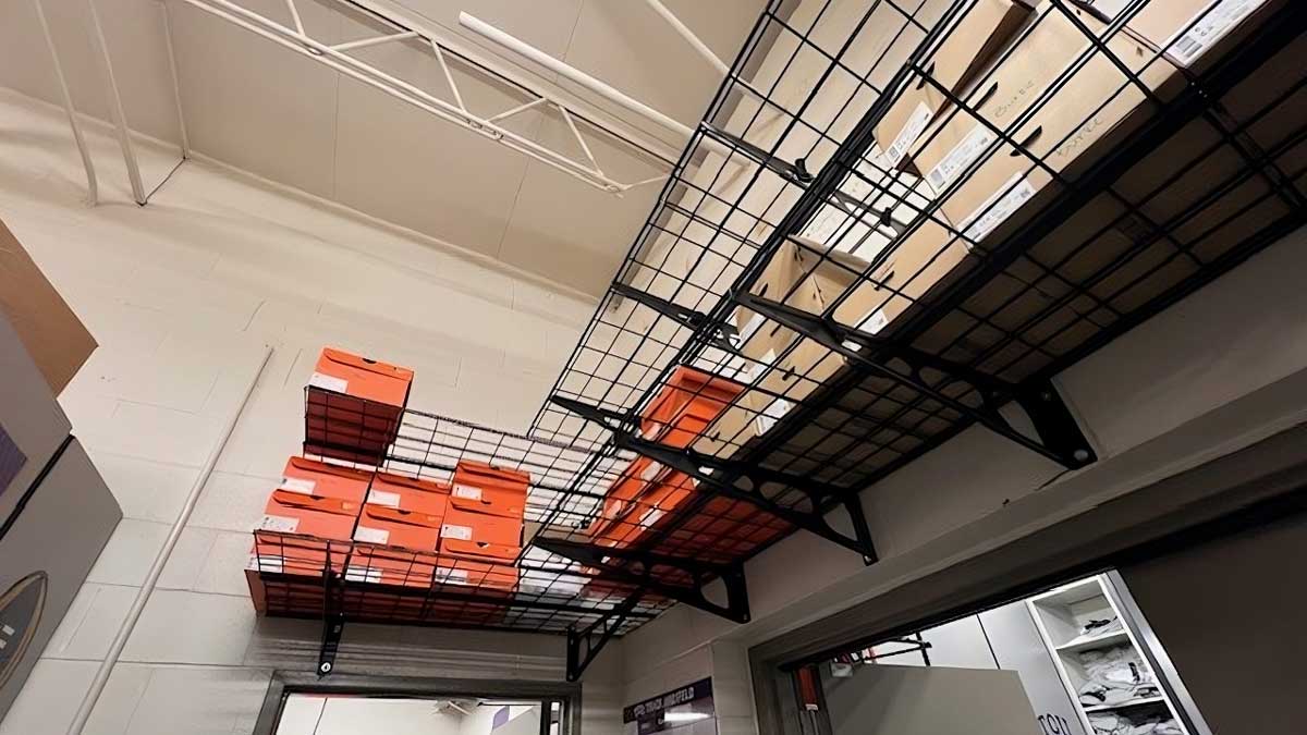 overhead metal wire basket shelving rack system storing shoeboxes above workspace