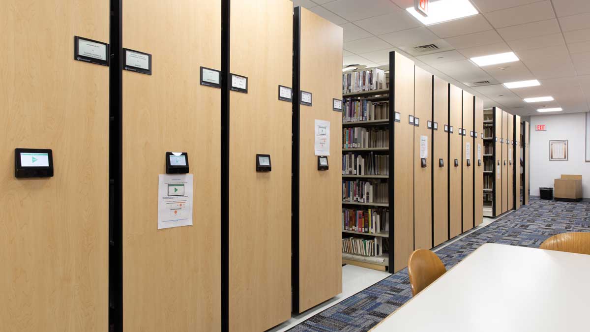 Powered mobile library shelving system for maximizing storage capacity and accessibility