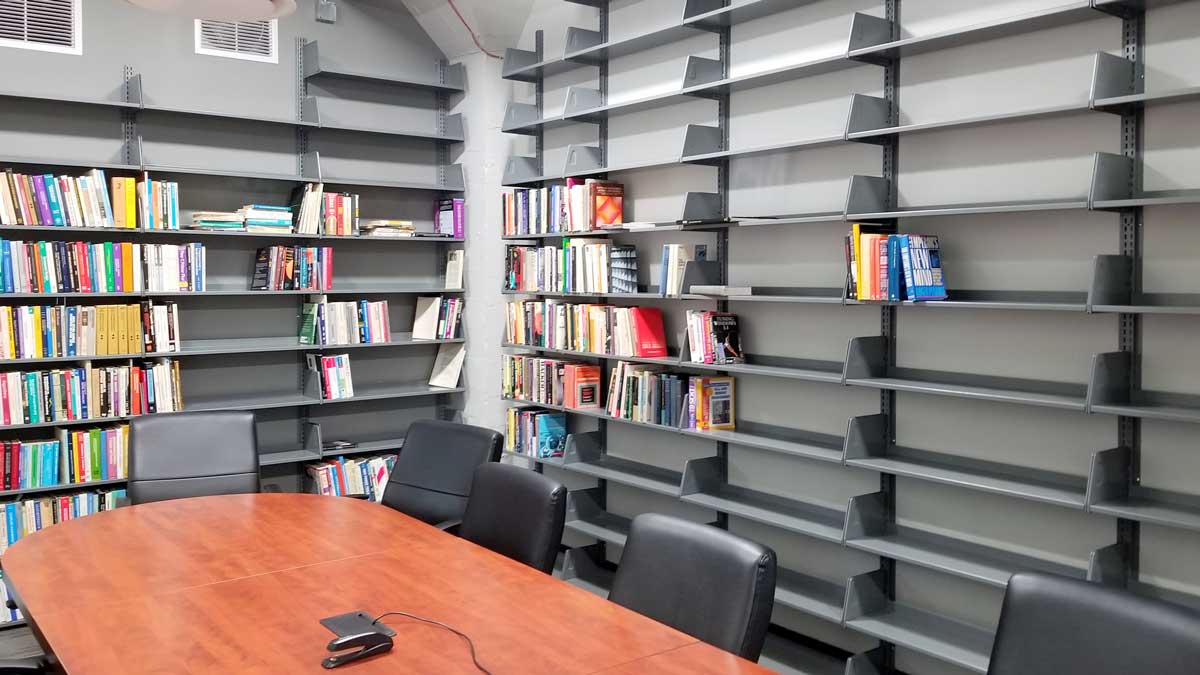 Wall-mounted library shelving units in a reading room for organized book storage and space saving