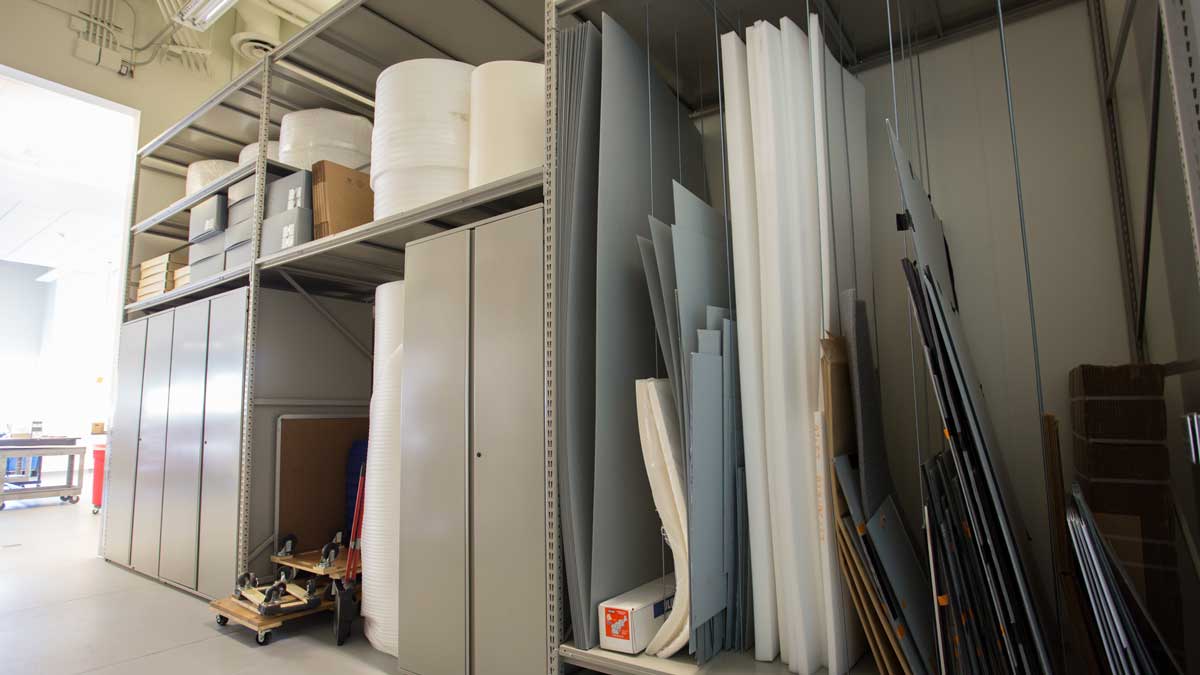 metal shelving units in a secure art storage environment, used for storing and organizing framed pieces and collection items