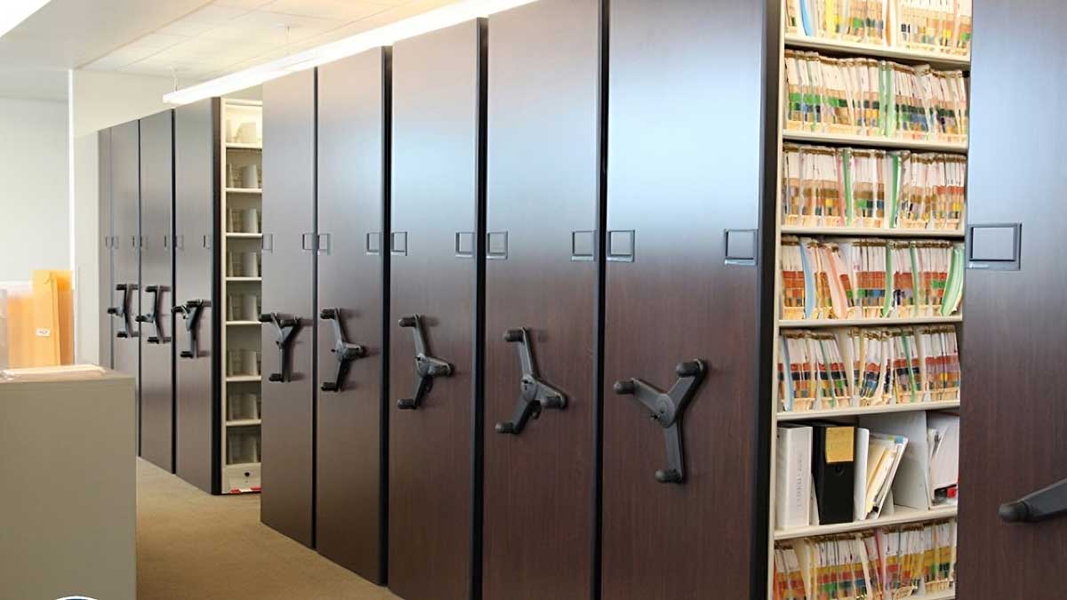 Color-coded medical file folders stored on high-density shelving