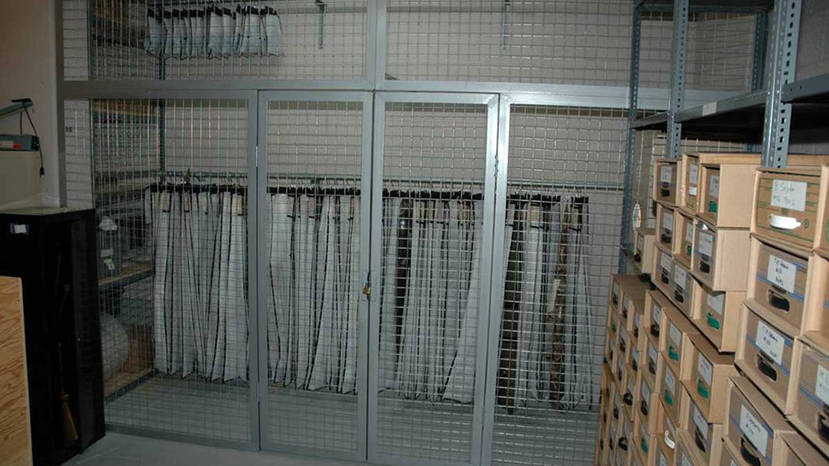 secure file archive with locked metal cage housing hanging pouches and boxed record storage for restricted access