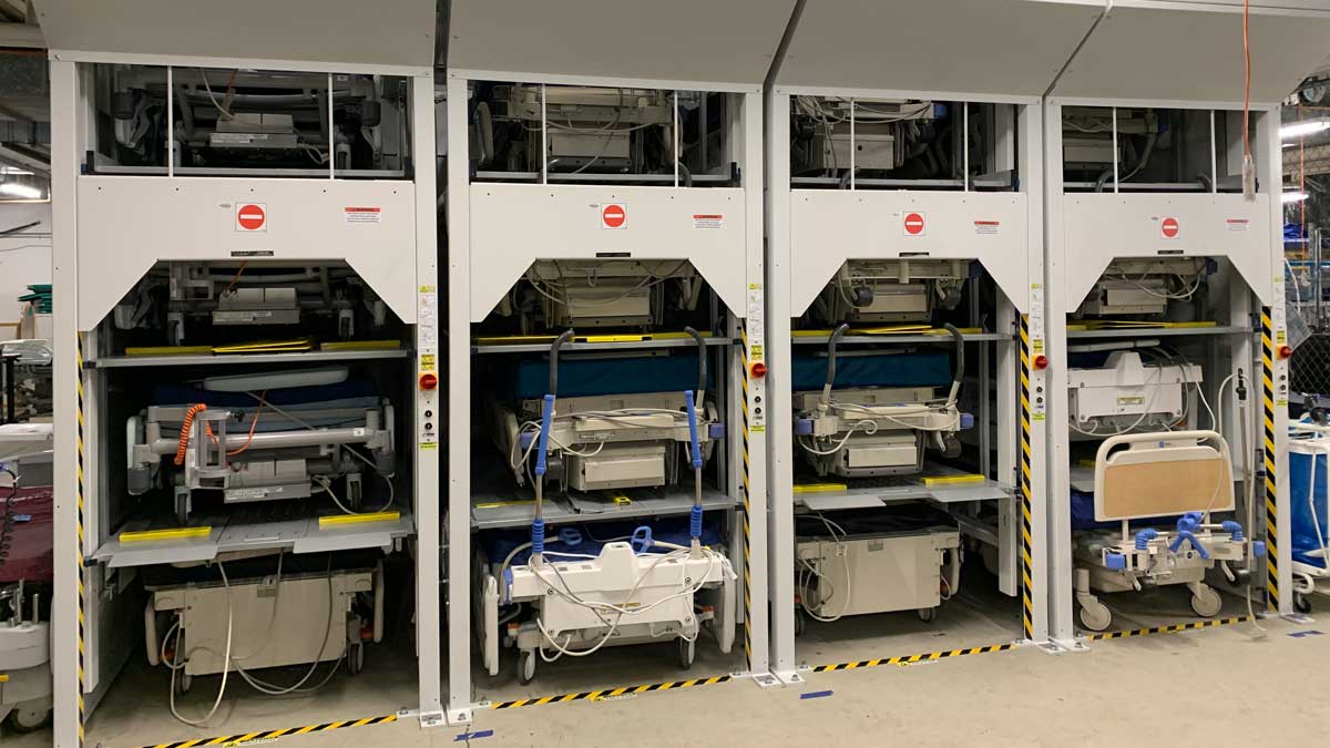 installed vertical storage lifts holding hospital beds in a healthcare facility
