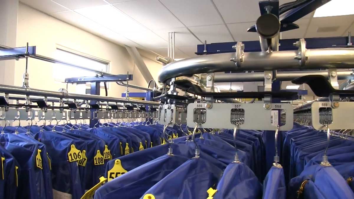 industrial conveyor system with tagged hanging garment bags for efficient automated sorting and retrieval