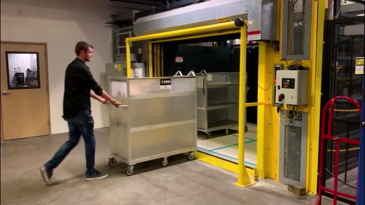 employee loads rolling cart into mezzanine lift for fast and safe multi-level inventory transport