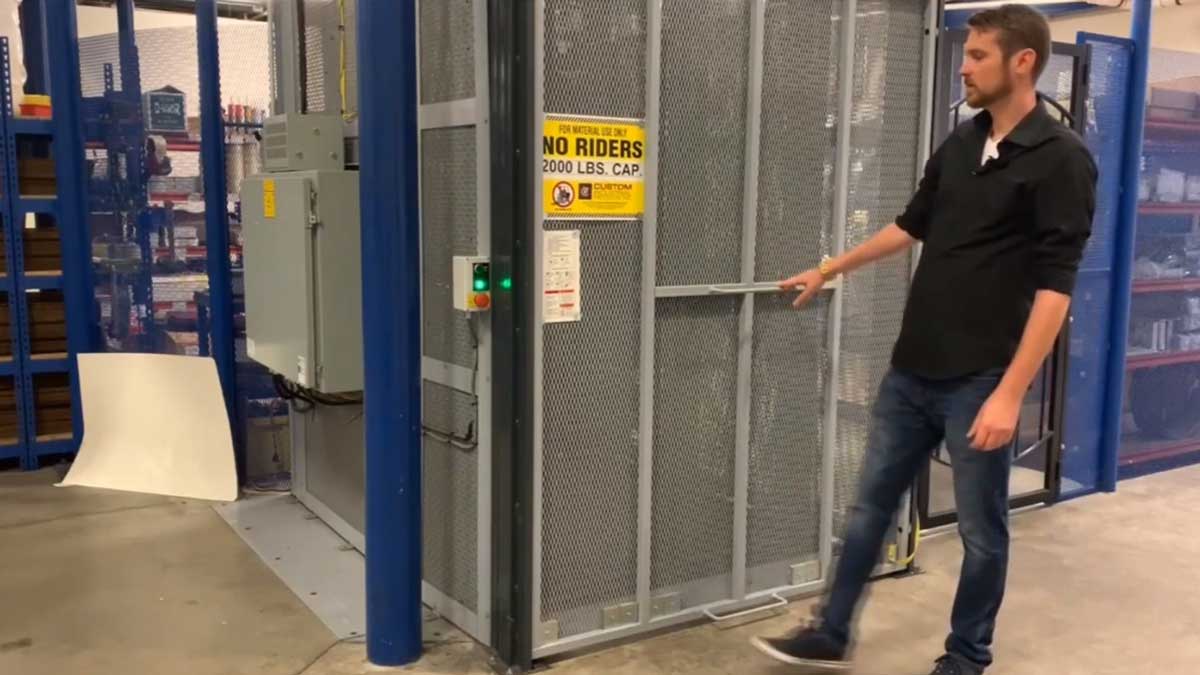 secured material lift door with safety signage for transporting inventory between mezzanine and ground level storage
