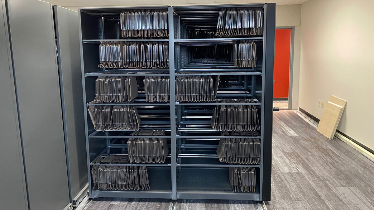 manual assist shelving system with oblique file folders for organized document storage and retrieval