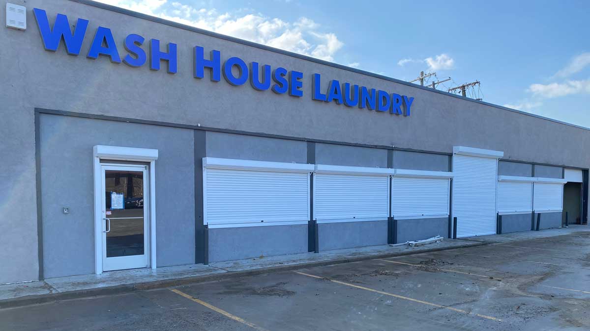 storefront security shutters closed on commercial laundry building for after-hours protection