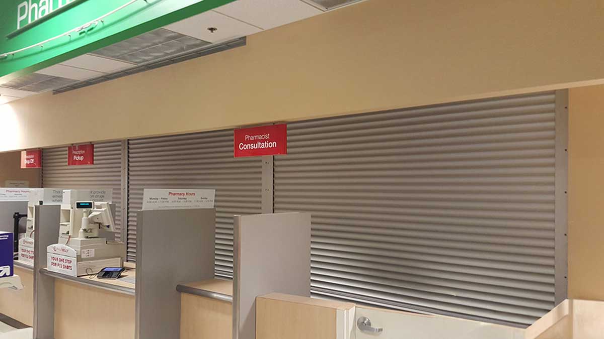 interior pharmacy counters secured with metal roll-down shutters for after-hours closure and compliance