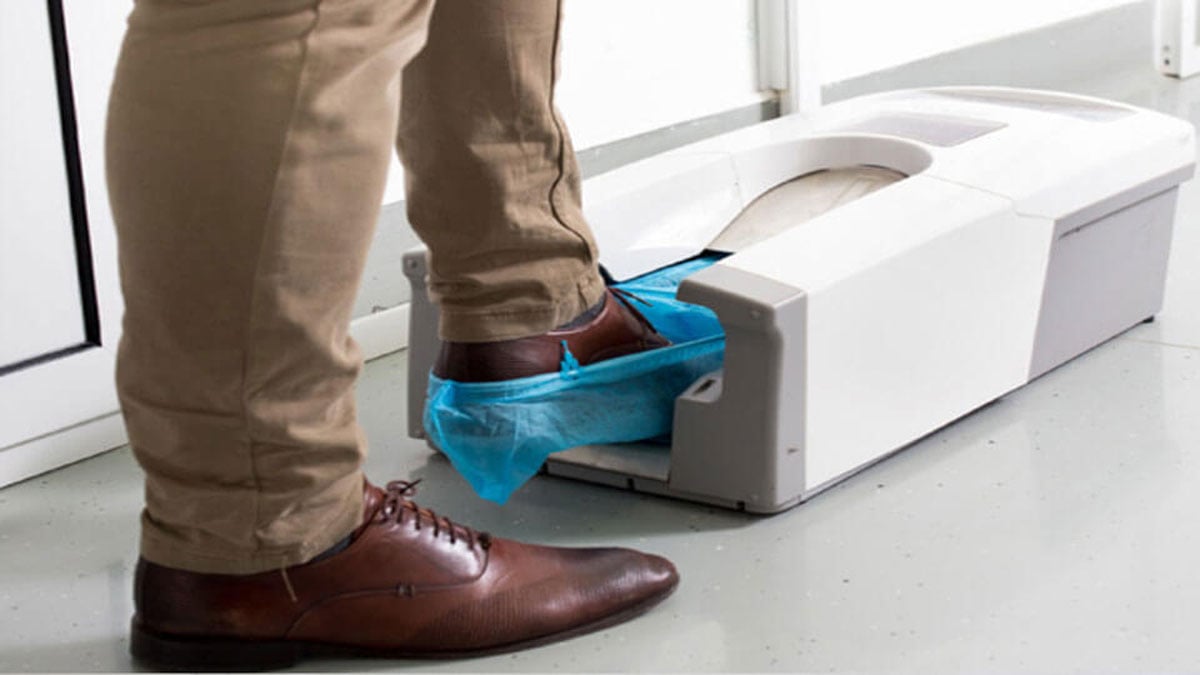 Front view of shoe cover dispenser showing viewing window and dispensing slot
