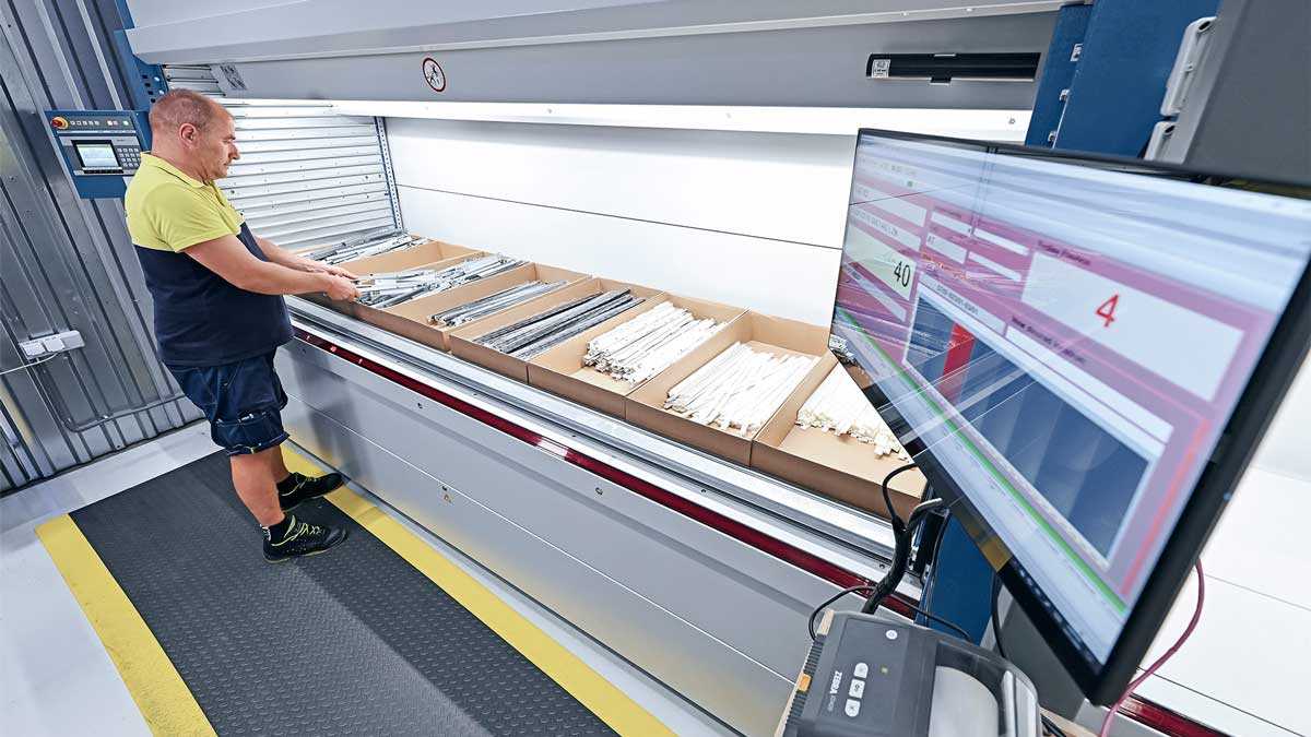 worker retrieving parts from vertical lift system integrated with picking software