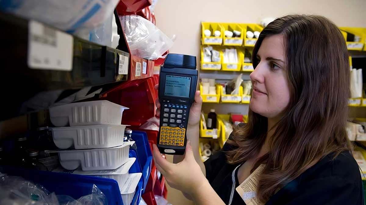 healthcare worker scanning medical supply bins with barcode device for inventory tracking and stock control