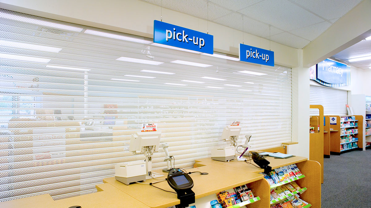 perforated roll-down security gates close pharmacy counters to prevent after-hours access