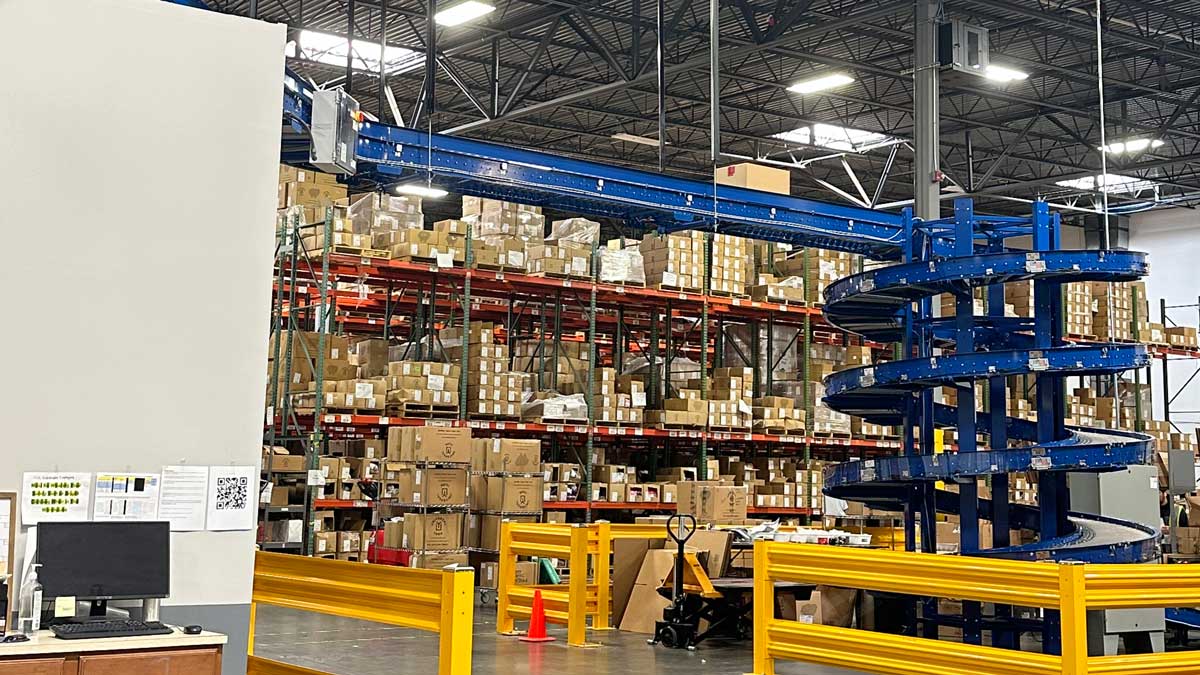 spiral conveyor system for efficient product transport in high-volume warehouse picking and packing operations