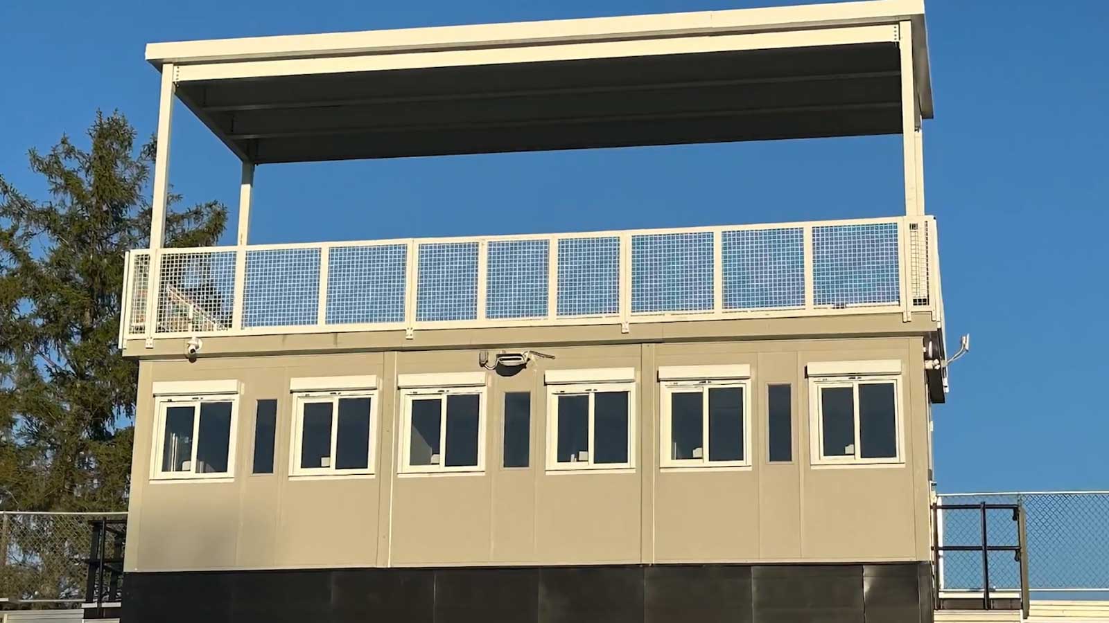 installed press box on stadium bleachers with overhead deck for camera use