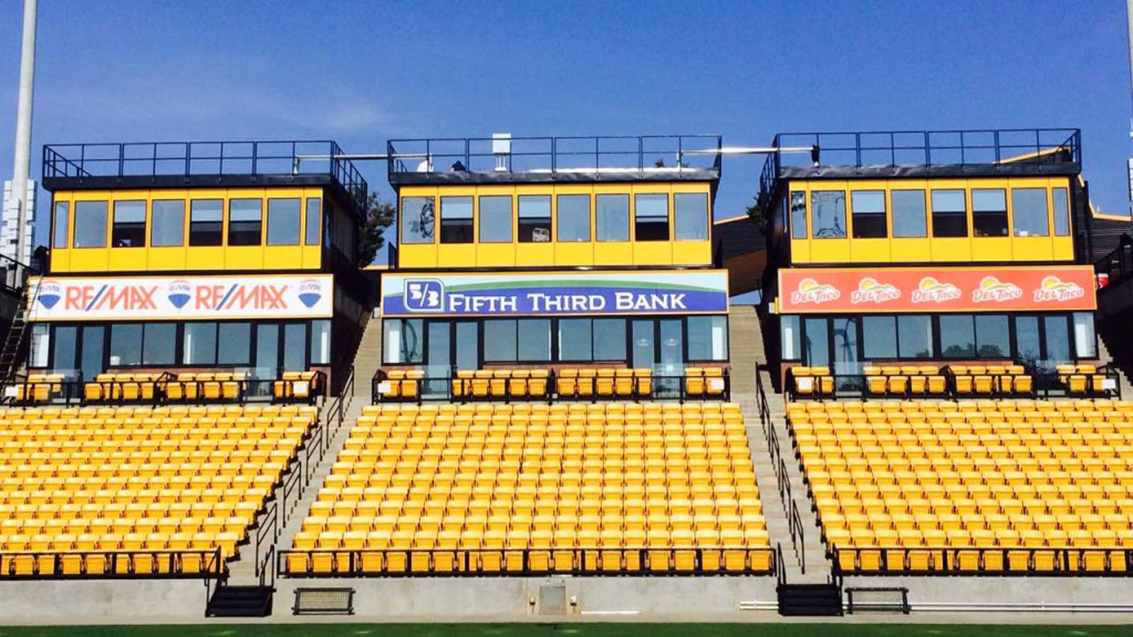 row of modular press boxes mounted above bleachers for media and VIP viewing