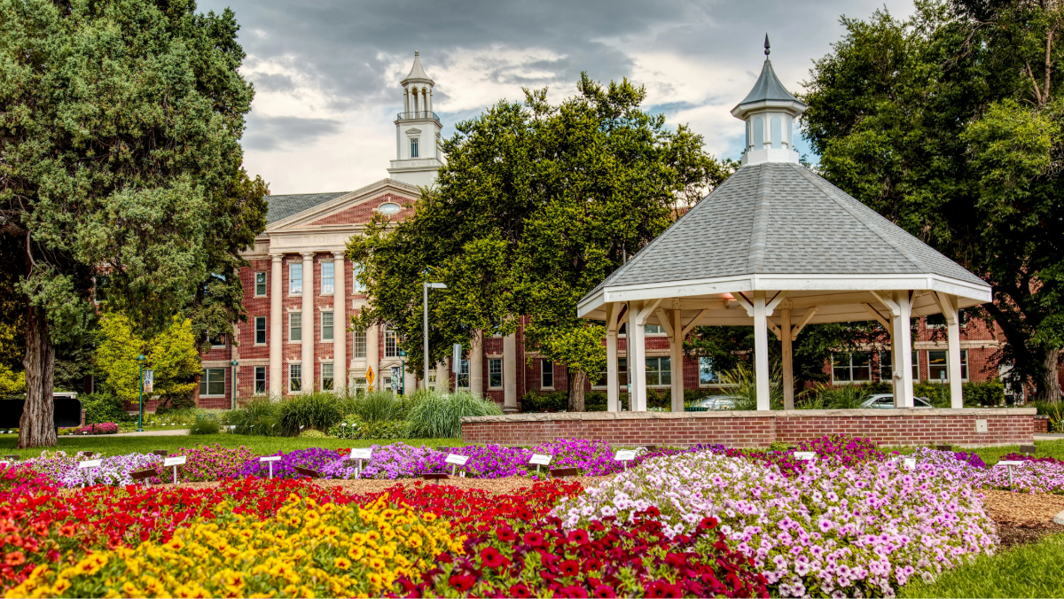 Historic campus gazebo Fort Collins with flower garden and academic building