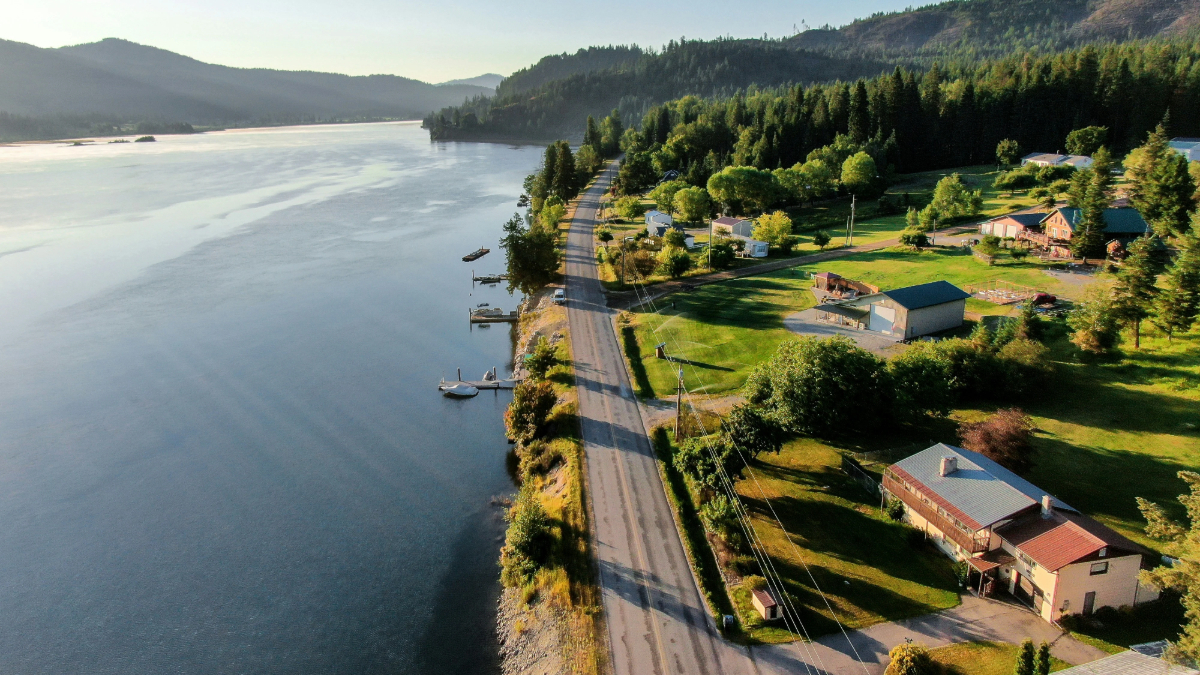 Lakeside residential view Coeur d Alene with shoreline road and forested hills
