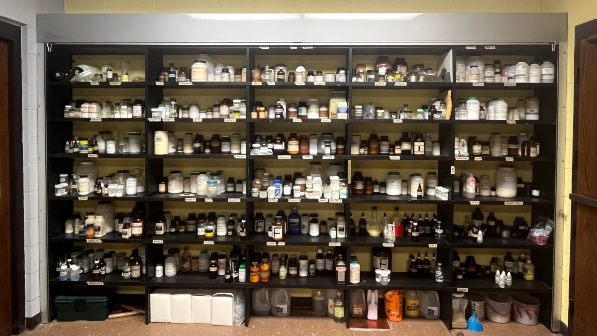 Science lab chemical storage shelving with organized bottles and classroom supply access